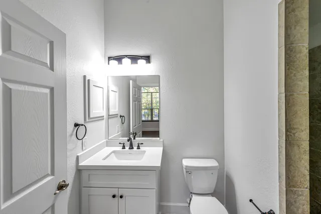 a bathroom with a toilet sink and mirror