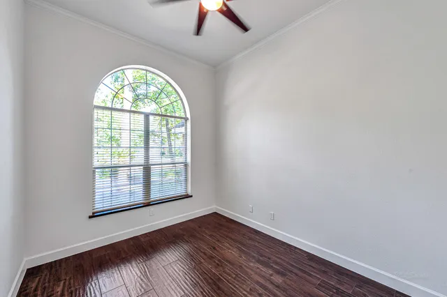an empty room with a window and wooden floor