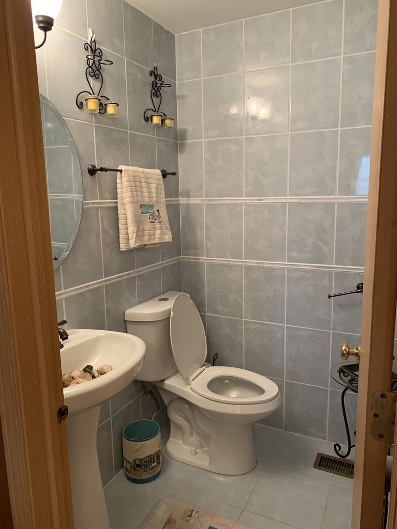 21211 Gray Hawk Drive Matteson, IL 60443 - Photo 17 of 36 a white toilet sitting next to a bathroom and a sink