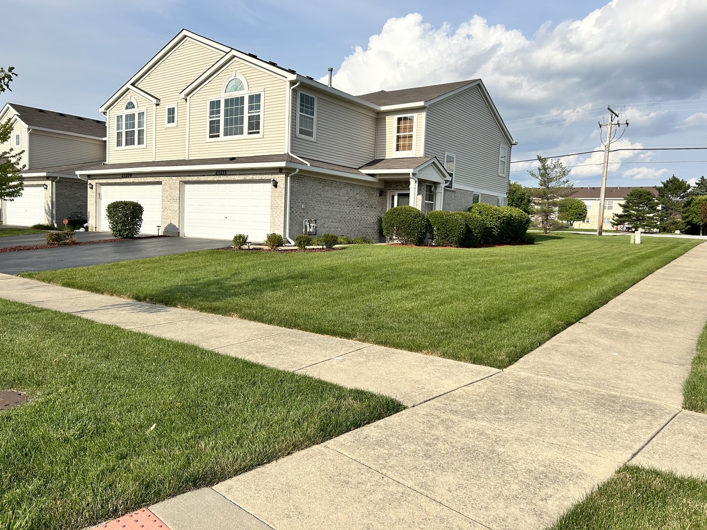 21211 Gray Hawk Drive Matteson, IL 60443 - Photo 3 of 36 a view of a white house with a big yard and potted plants