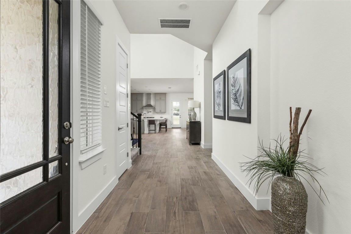 904 Arundel Road Lakeway, TX 78738 - Photo 3 of 40 a view of a hallway with wooden floor and a potted plant