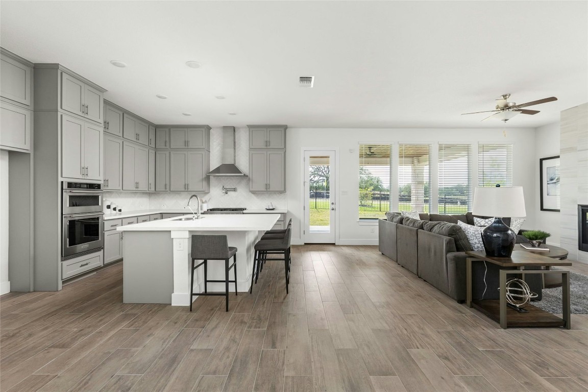 904 Arundel Road Lakeway, TX 78738 - Photo 7 of 40 a kitchen with kitchen island granite countertop a sink cabinets and wooden floor