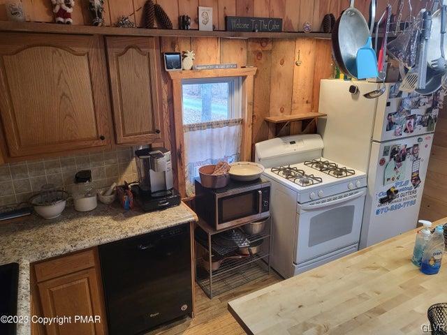 125 Ness Road Dingmans Ferry, PA 18328 - Photo 11 of 29 a kitchen with stainless steel appliances granite countertop a sink stove and cabinets