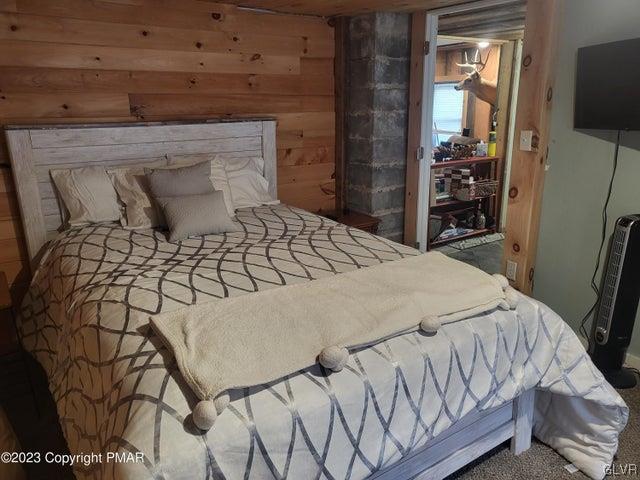 125 Ness Road Dingmans Ferry, PA 18328 - Photo 16 of 29 a bedroom with a bed and a flat tv screen on dresser