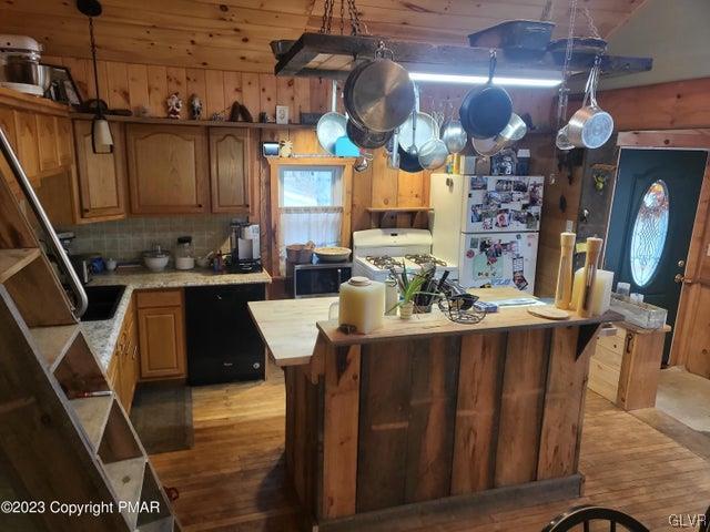 125 Ness Road Dingmans Ferry, PA 18328 - Photo 9 of 29 a kitchen with stainless steel appliances granite countertop a sink a stove and a wooden floors