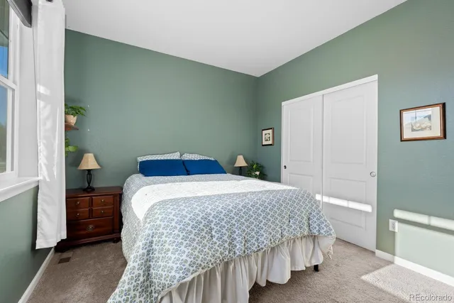 a bedroom with a bed and a painting on the wall