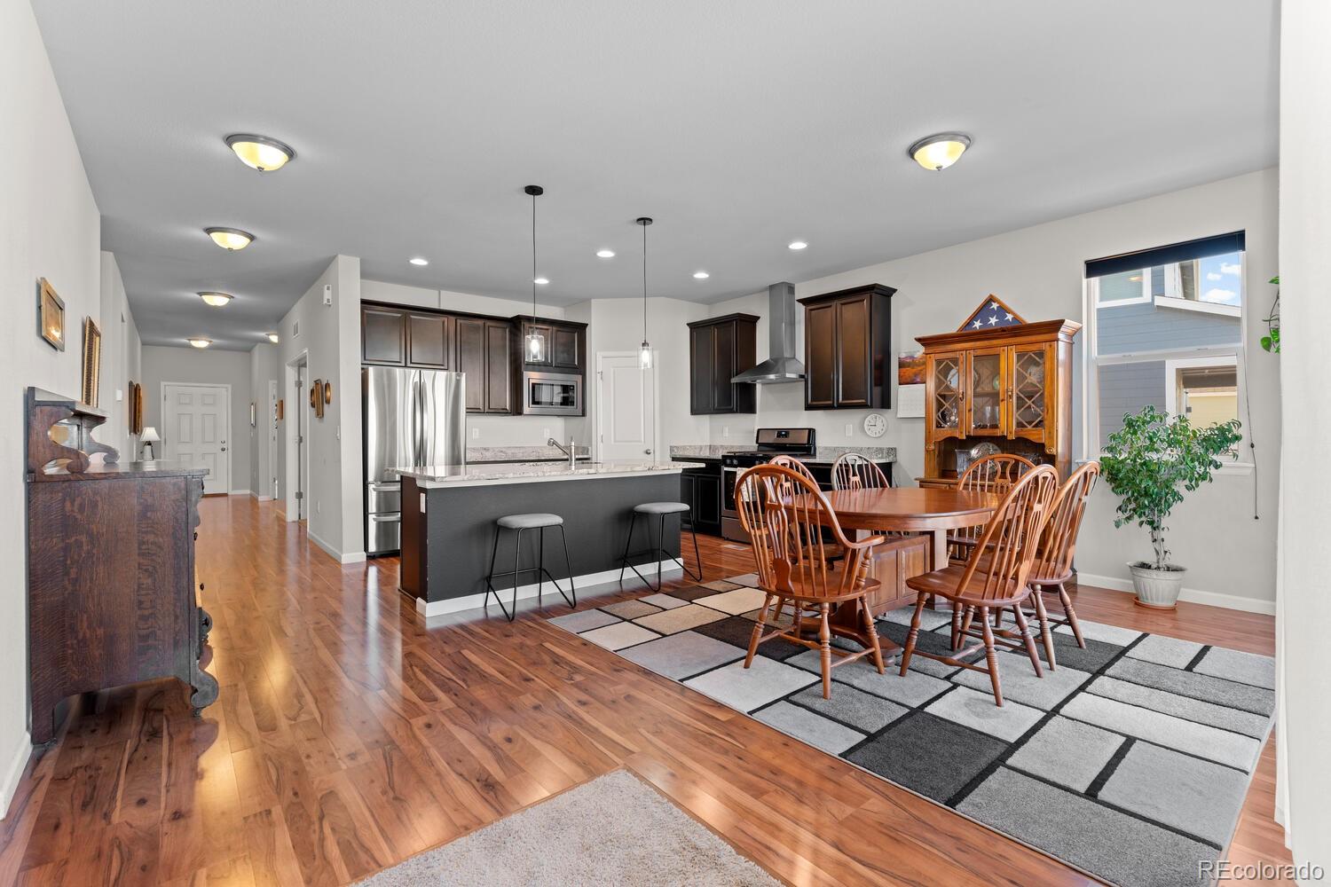 1587 Lake Point Way Severance, CO 80550 - Photo 21 of 40 a open kitchen with stainless steel appliances a dining table chairs and granite counter tops