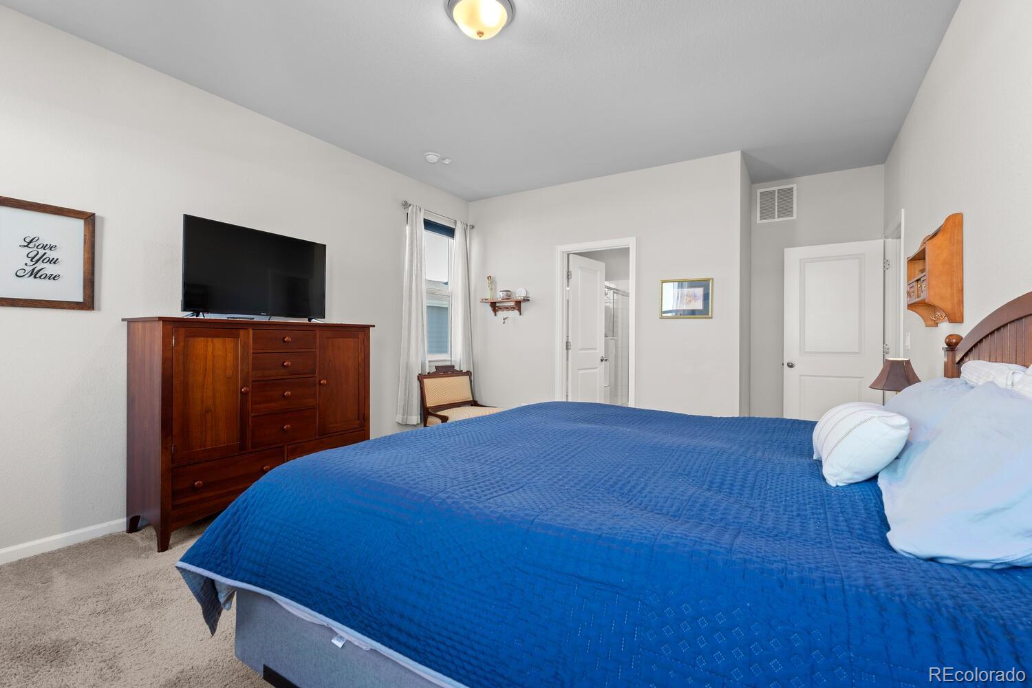 1587 Lake Point Way Severance, CO 80550 - Photo 24 of 40 a bedroom with a bed and a flat screen tv