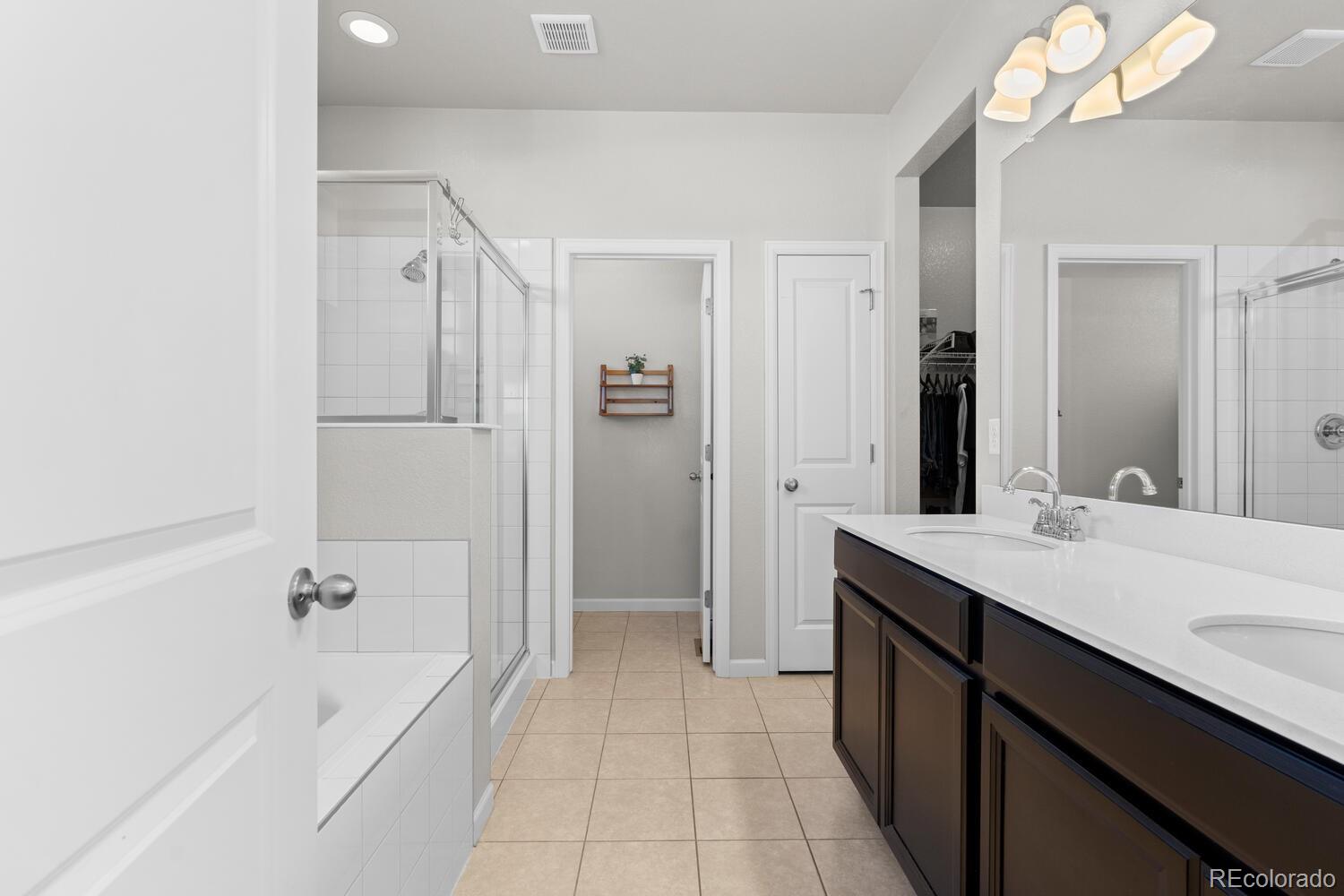 1587 Lake Point Way Severance, CO 80550 - Photo 25 of 40 a bathroom with a tub sink shower and a mirror