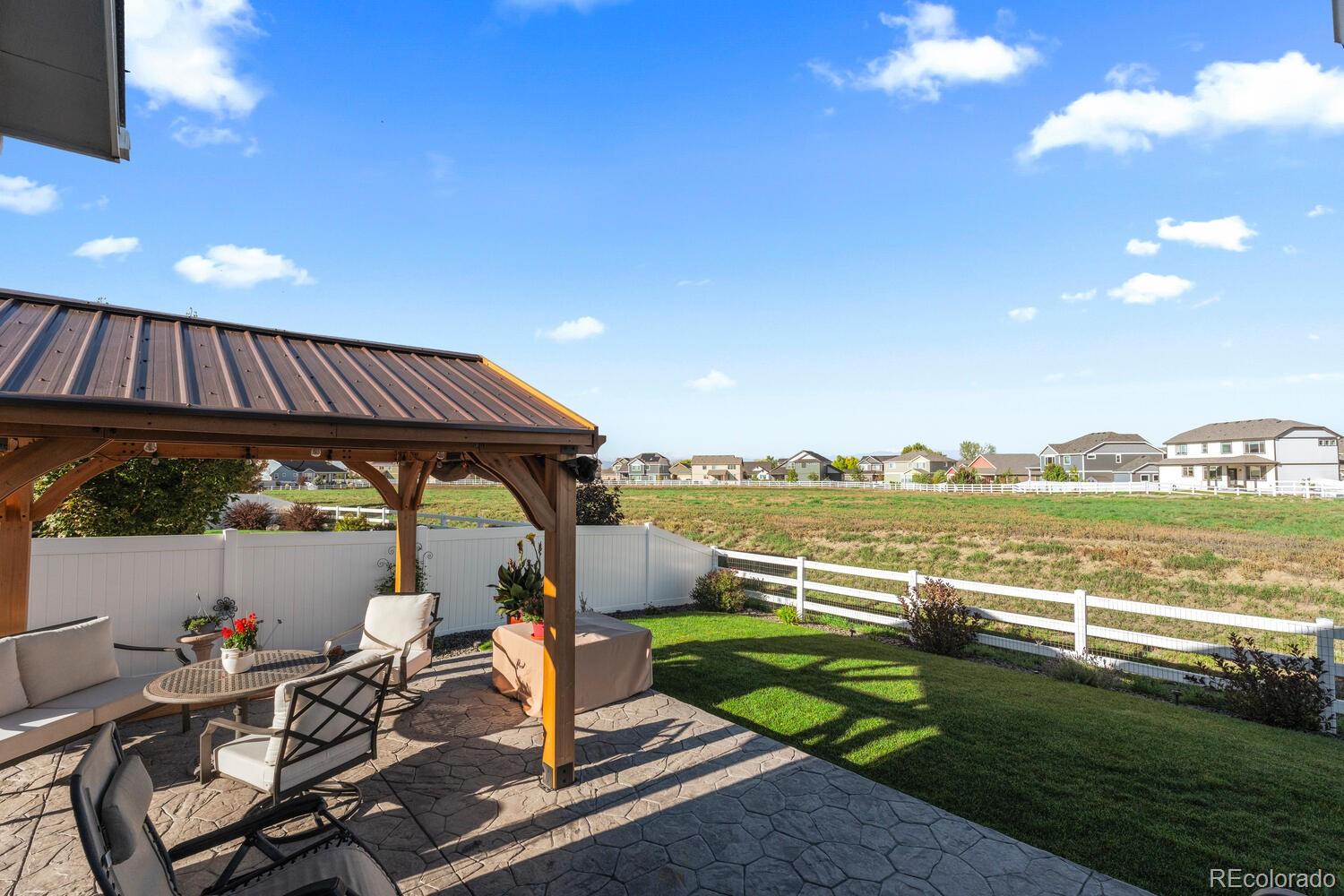 1587 Lake Point Way Severance, CO 80550 - Photo 37 of 40 a view of a chair and tables in the patio next to a yard
