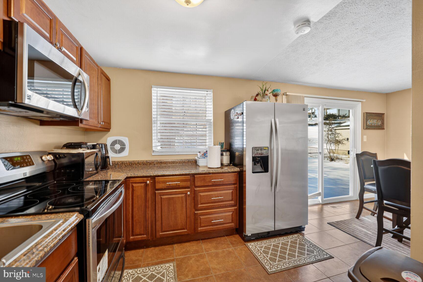 12611 Windbrook Drive Clinton, MD 20735 - Photo 11 of 32 a kitchen with stainless steel appliances granite countertop a refrigerator and a stove top oven