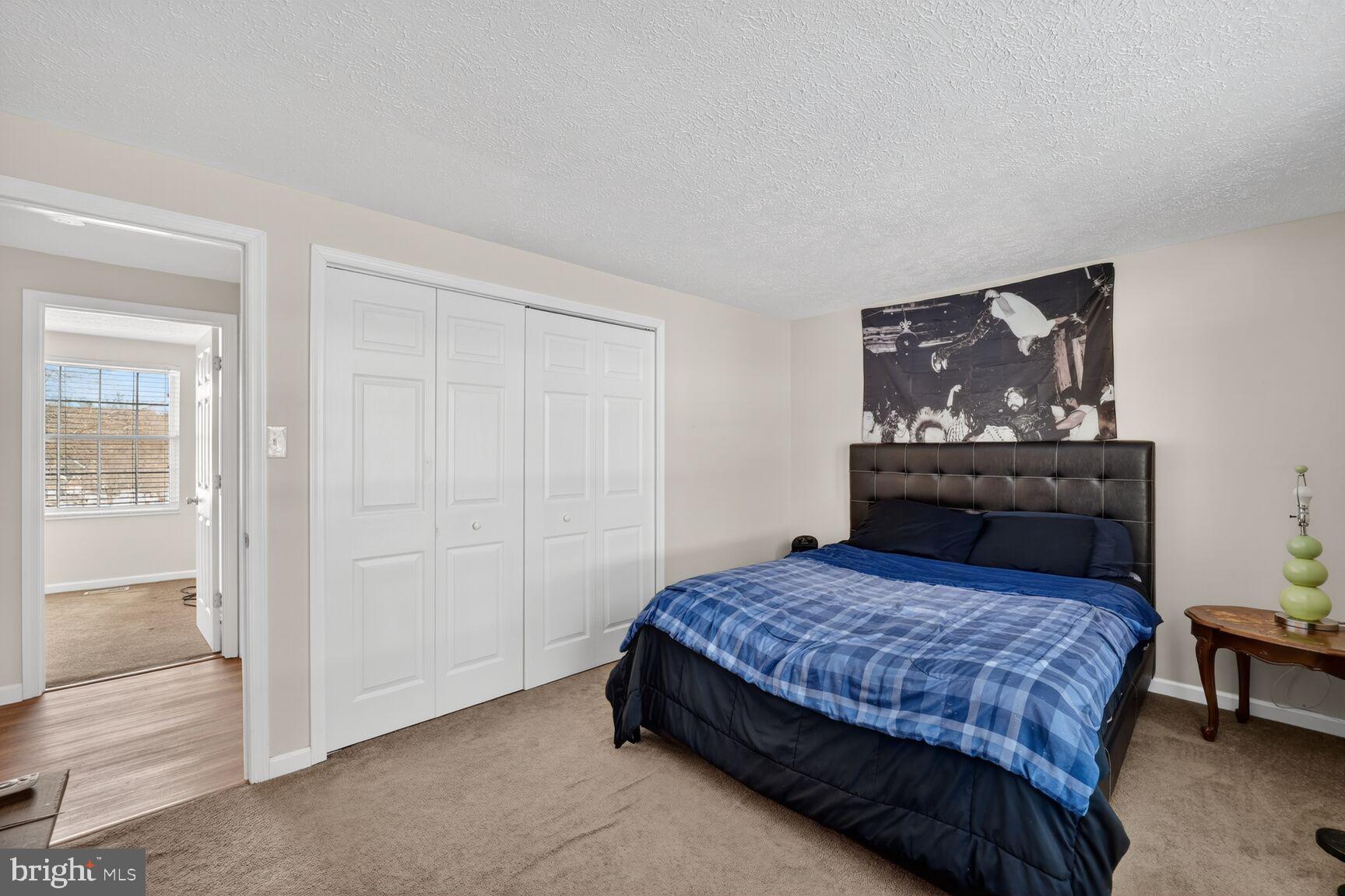 12611 Windbrook Drive Clinton, MD 20735 - Photo 15 of 32 a bedroom with a bed and a painting on the wall