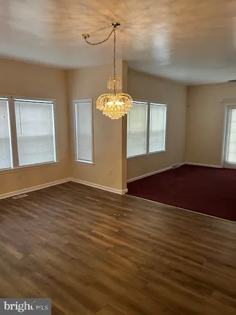 a view of a room with window wooden floor and chandelier