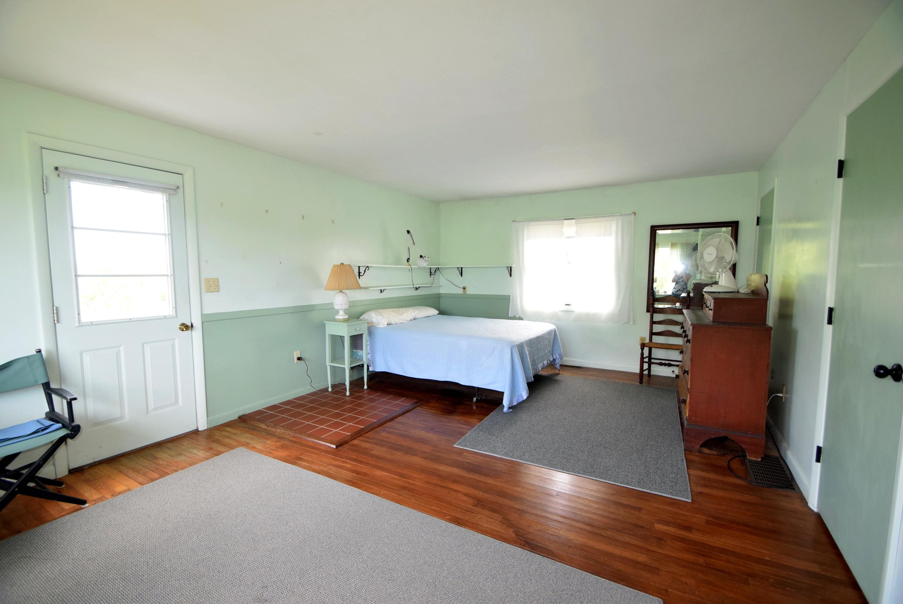 2 Ryder Hollow Road Truro, MA 02666 - Photo 23 of 31 a spacious bedroom with a bed and wooden floor