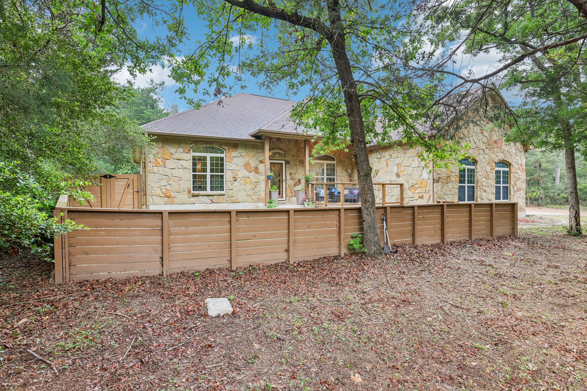 267 Corral Road Smithville, TX 78957 - Photo 5 of 40 Stone-clad exterior featuring multiple windows and a covered porch