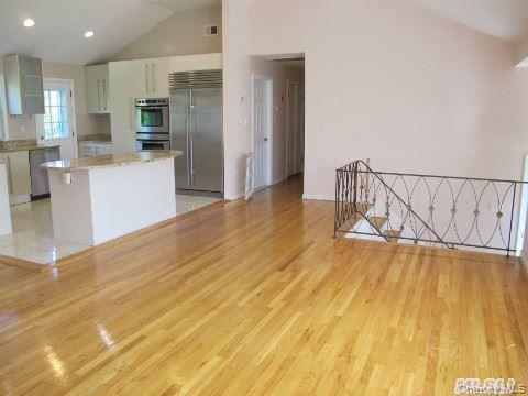 5 Elm Street Great Neck, NY 11021 - Photo 4 of 17 a view of a kitchen with stainless steel appliances wooden floor and chair