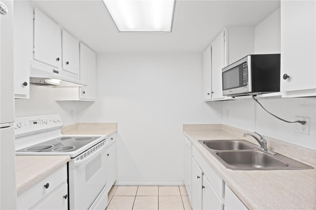 920 Lake Destiny Road, Unit F Altamonte Springs, FL 32714 - Photo 5 of 27 a kitchen with white cabinets sink and white appliances