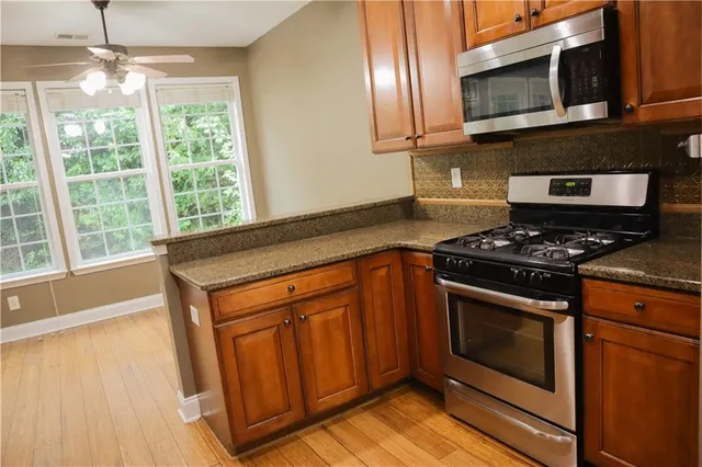 a kitchen with stainless steel appliances granite countertop a stove and a microwave