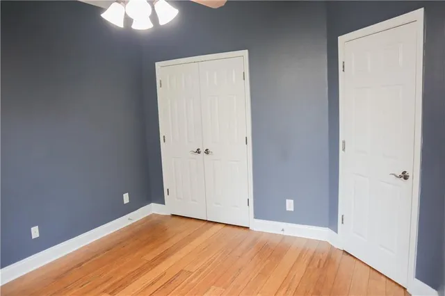 a view of an empty room with a chandelier fan