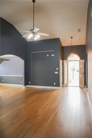 a view of an empty room with window and wooden floor