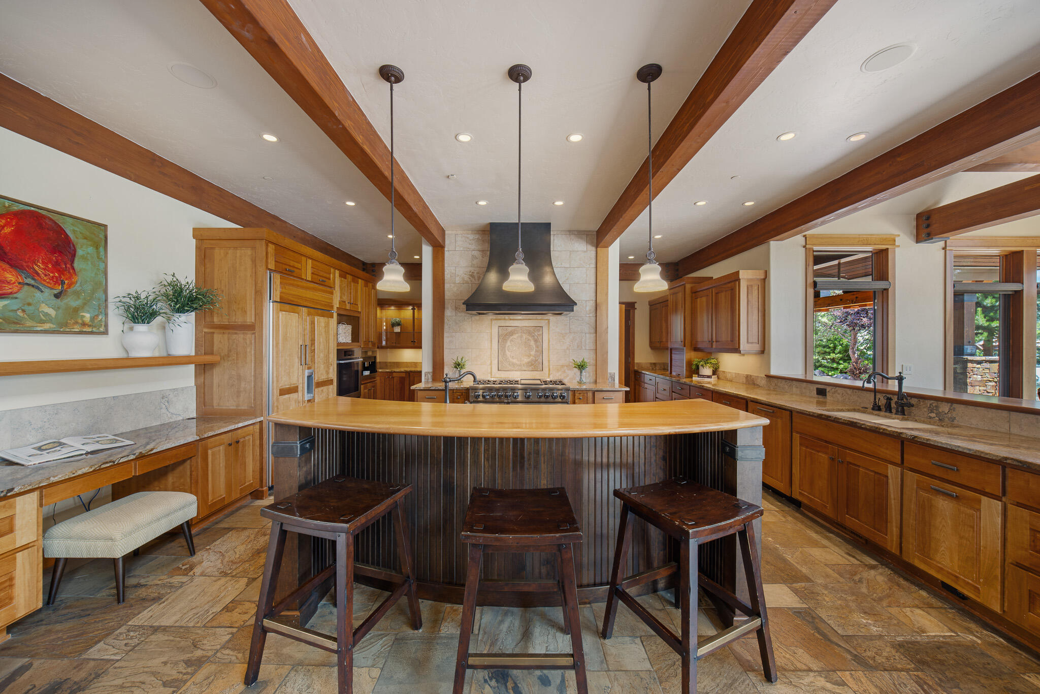 18883 Sutherland Court Bend, OR 97702 - Photo 9 of 70 A chef?s showcase?curved island with veined granite, cherry cabinetry, and seating for six creates the perfect gathering space.