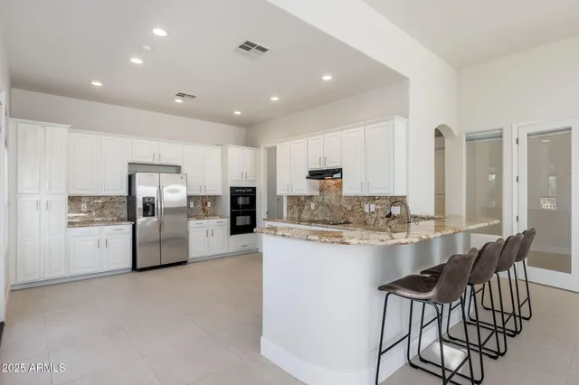 a kitchen with stainless steel appliances kitchen island granite countertop a table and chairs