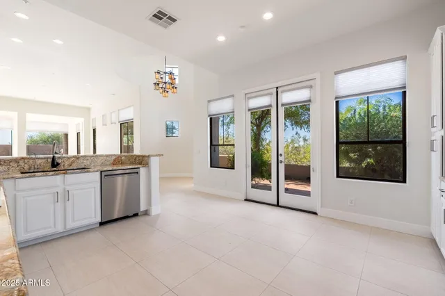 a large white kitchen with granite countertop a large window