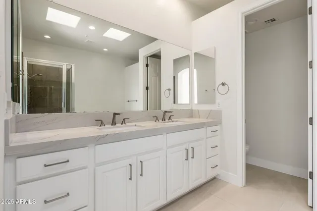 a bathroom with double sink and a mirror