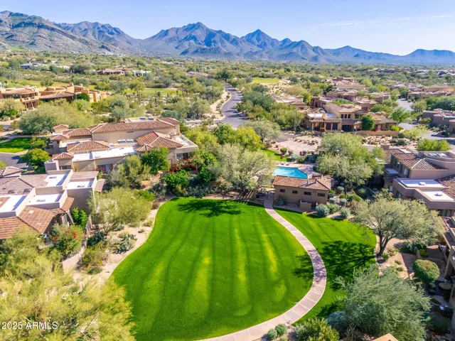 an aerial view of a house with a mountain