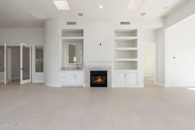 a view of an empty room with a fireplace and a window