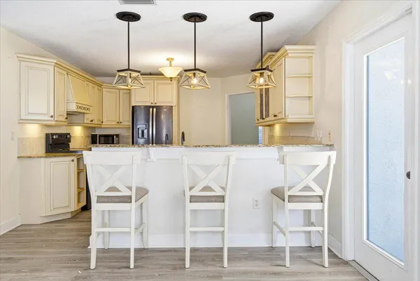 a kitchen with stainless steel appliances kitchen island granite countertop a dining table chairs and granite counter tops