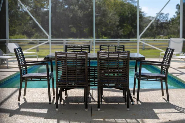 a view of a swimming pool with a patio and a yard