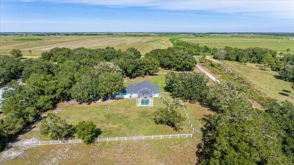 an aerial view of a house with a garden and lake view