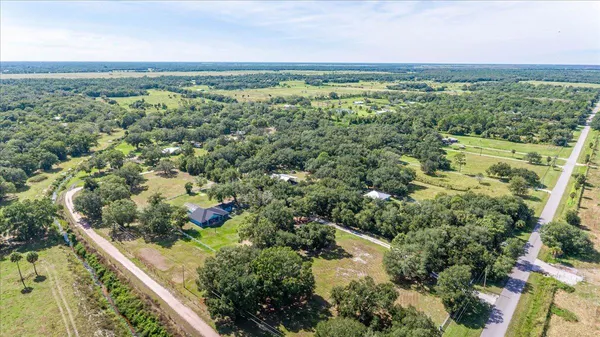 an aerial view of a house with a yard and lake view