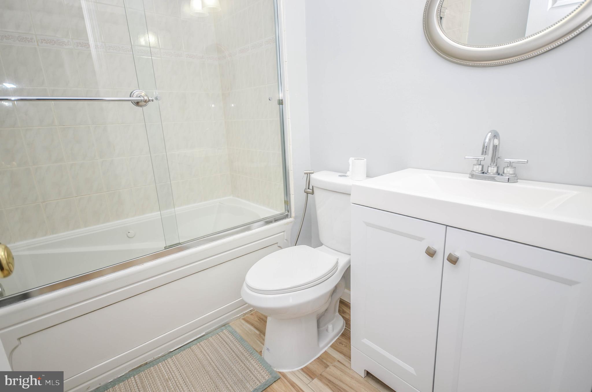 9801 Belhaven Road Bethesda, MD 20817 - Photo 20 of 32 a bathroom with a sink a toilet and a mirror