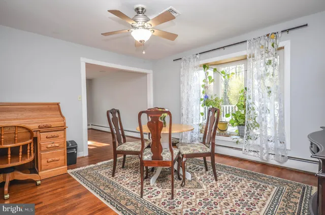 a dining room with furniture a rug a chandelier and wooden floor