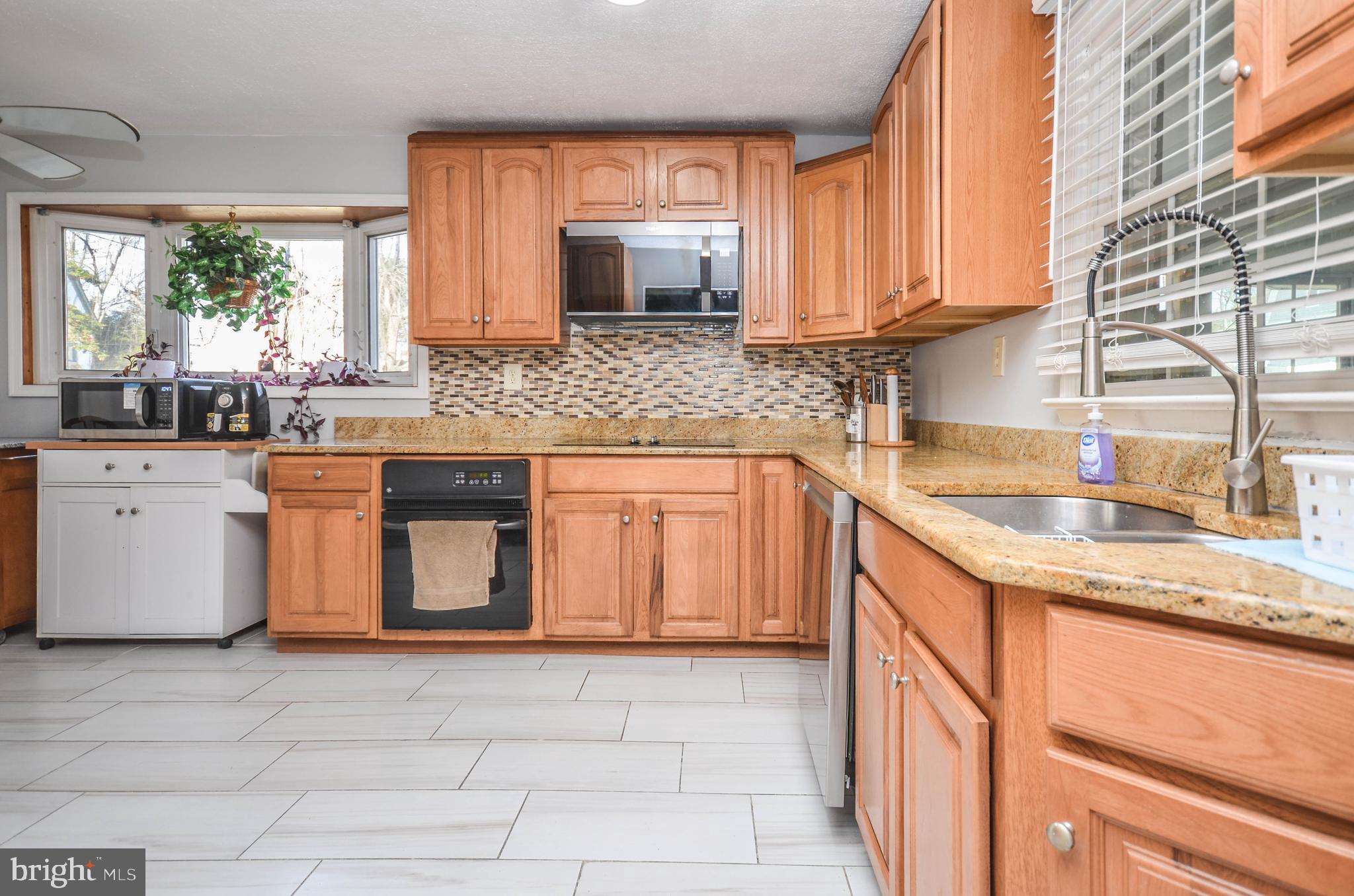 9801 Belhaven Road Bethesda, MD 20817 - Photo 8 of 32 a kitchen with stainless steel appliances granite countertop a sink stove and cabinets