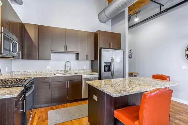 a kitchen with stainless steel appliances granite countertop a sink stove and refrigerator
