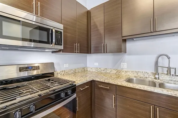 a kitchen with granite countertop a stove and a sink