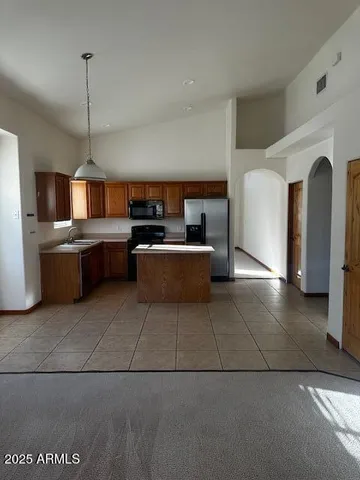 a living room with couches and kitchen view