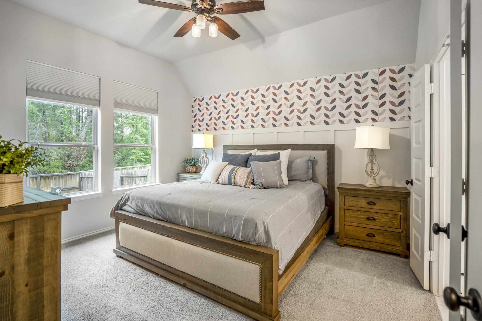 334 Topper Pines Drive Montgomery, TX 77316 - Photo 18 of 49 Just off the hallway, the primary bedroom feels bright without needing much fuss, with backyard light coming through the window and a patterned accent wall adding personality behind the bed wall.