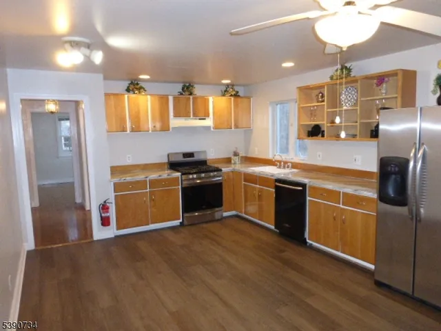 a kitchen with stainless steel appliances granite countertop a stove top oven and refrigerator