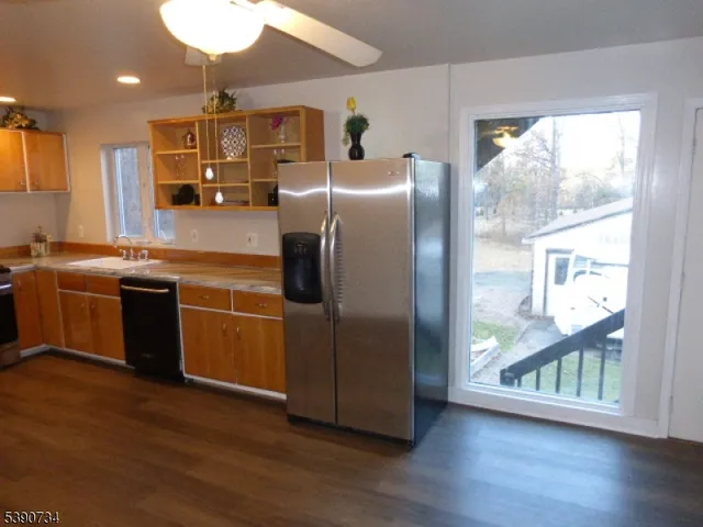 a kitchen with stainless steel appliances granite countertop a refrigerator a sink a stove and wooden floors