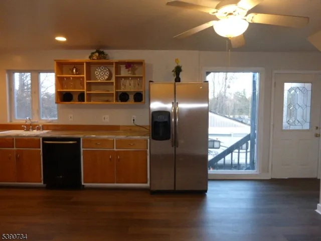 a kitchen with kitchen island granite countertop wooden floors and a large window