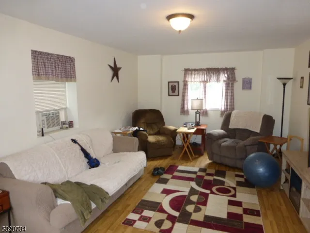 a living room with furniture a flat screen tv and a window