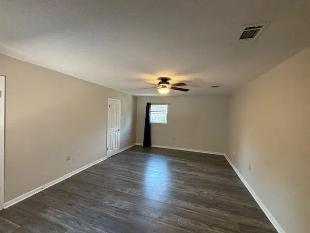 a view of empty room with wooden floor