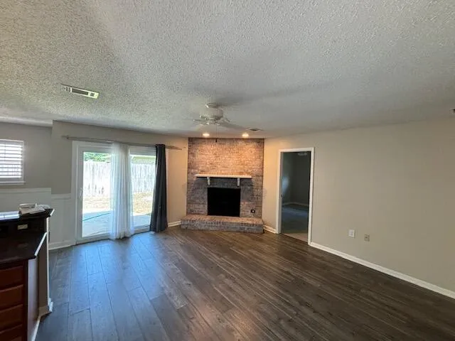 an empty room with wooden floor and fireplace