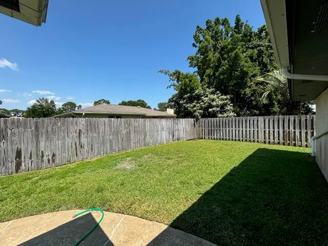 a view of a backyard with wooden fence