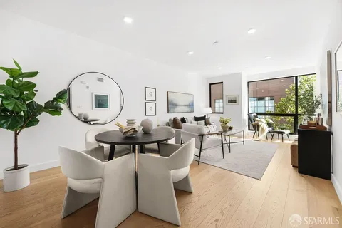 a living room with furniture a potted plant and a large window