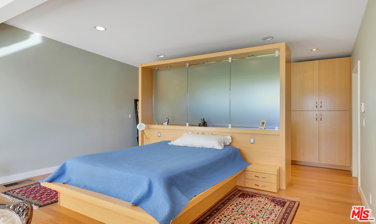 3921 Cody Road Sherman Oaks, CA 91403 - Photo 14 of 36 a bedroom with a bed and wooden floor